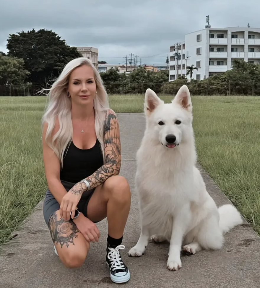 Nicole kneeling next to Neo, her white Berger Blanc Suisse